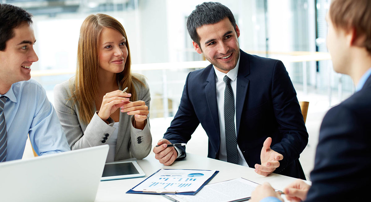 A group of happy coworkers collaborating on a project, using the Besanz communication platform on their devices.